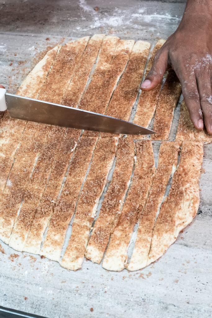 Cutting filled dough into strips with sharp knife