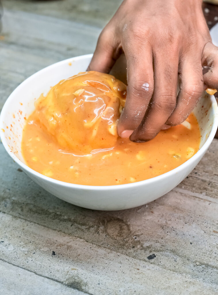 Dipping Korean bun in custard filling mixture