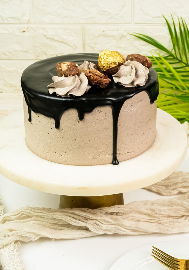 Elegant Ferrero Rocher cake presentation on white marble cake stand