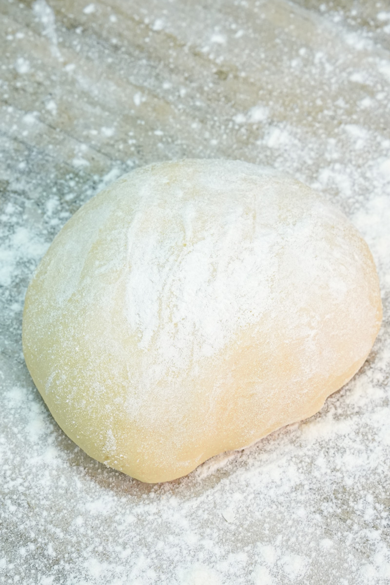 Empanada dough ball on floured surface
