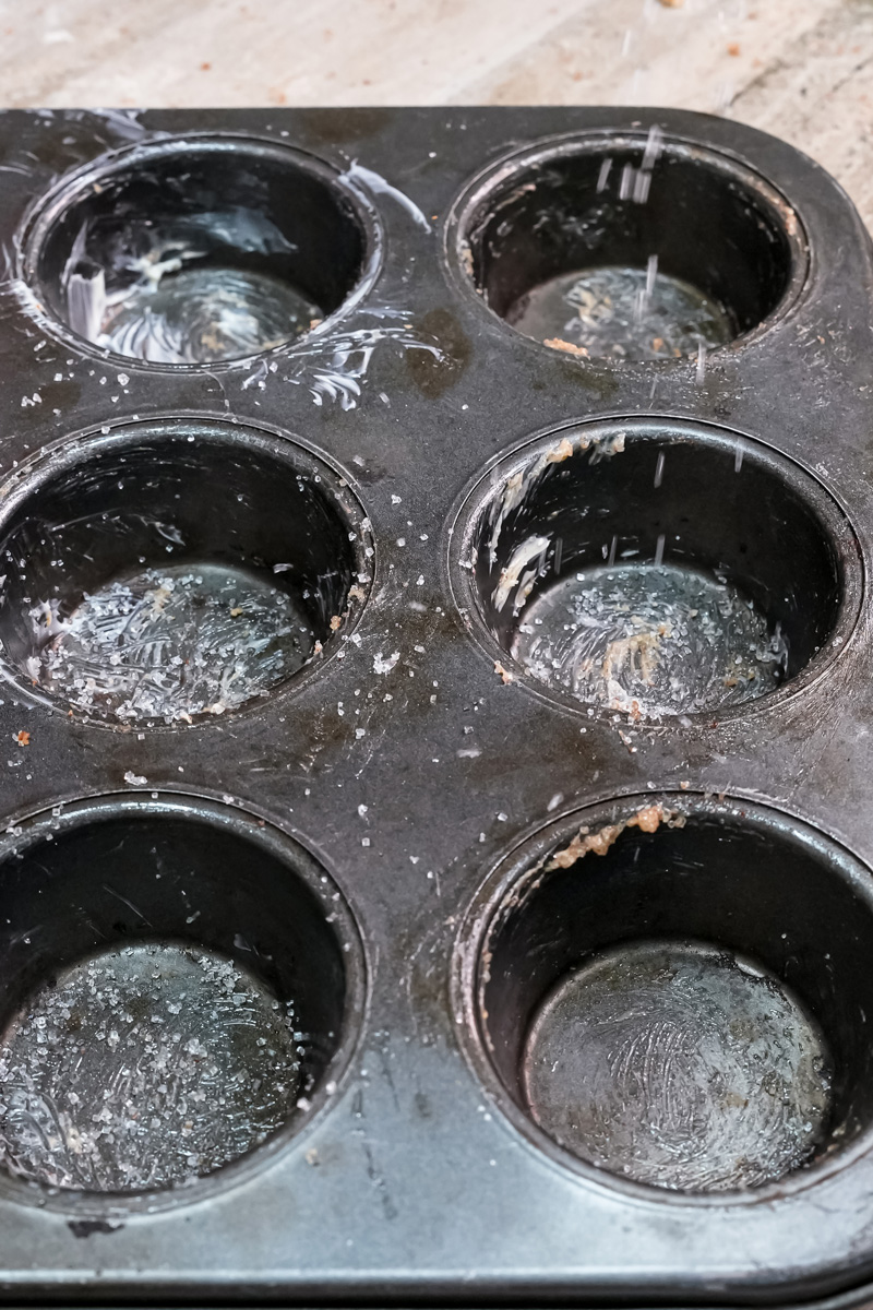 Empty greased muffin tin prepared for cruffins
