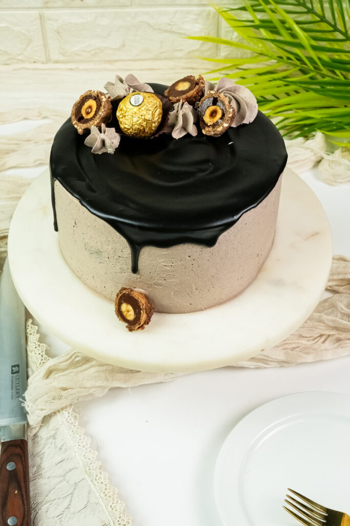 Complete Ferrero Rocher cake with black chocolate glaze and decorative ribbons