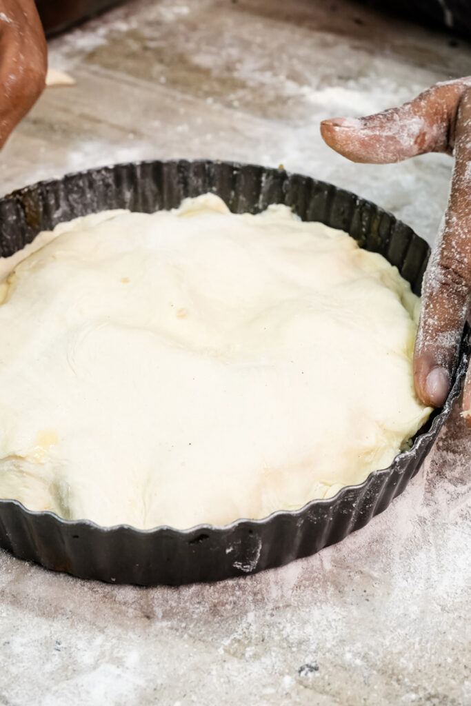 Fitting puff pastry over apples for upside-down French tart