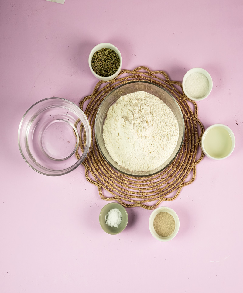 Focaccia bread ingredients layout - flour, rosemary, oil, salt, yeast