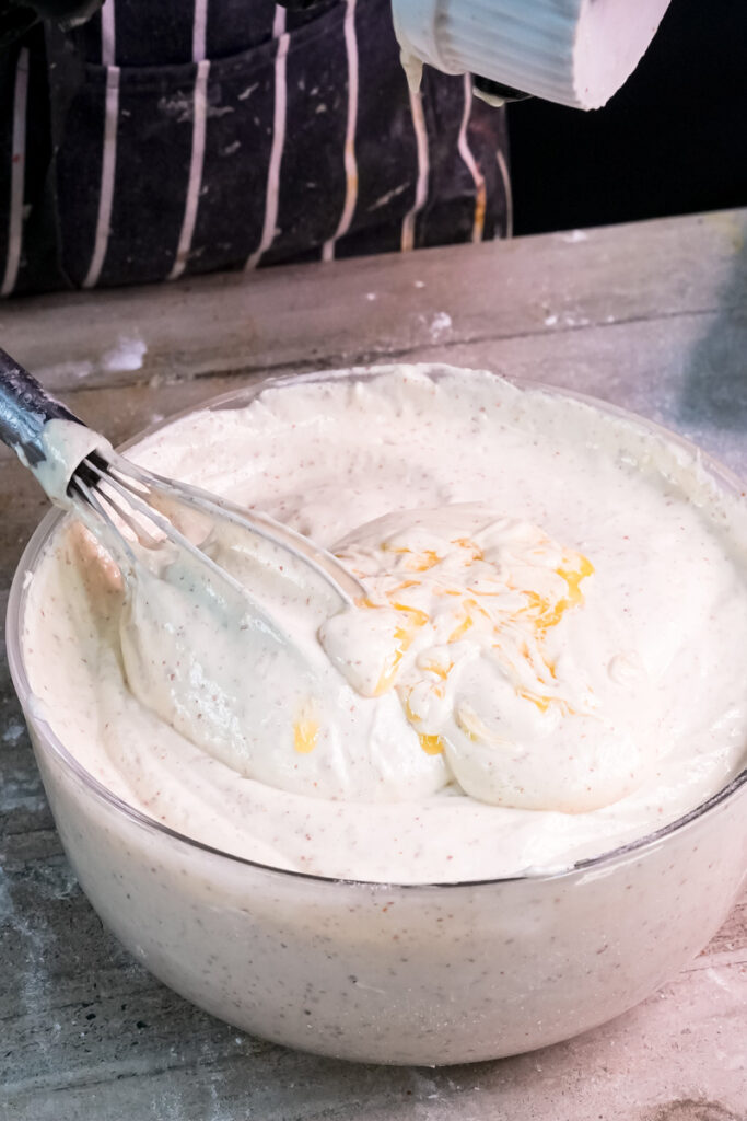 Folding opera cake batter with whisk showing proper mixing technique"