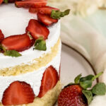 Close-up of Fraisier cake with fresh strawberries and whipped cream