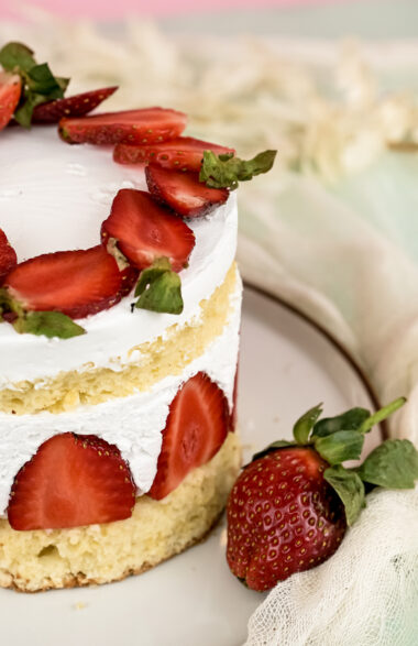 Close-up of Fraisier cake with fresh strawberries and whipped cream
