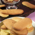 Fresh baked ladyfinger cookies on white plate close-up
