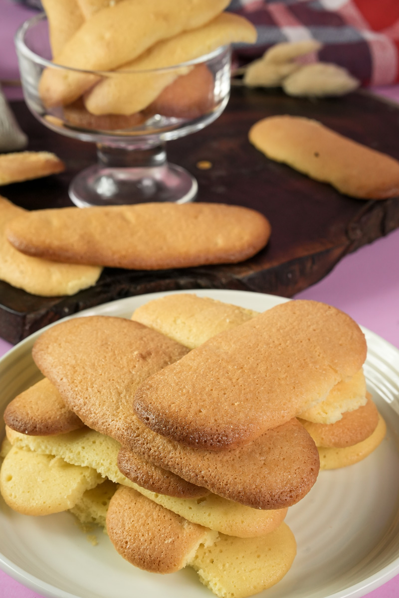 Fresh baked ladyfinger cookies on white plate close-up