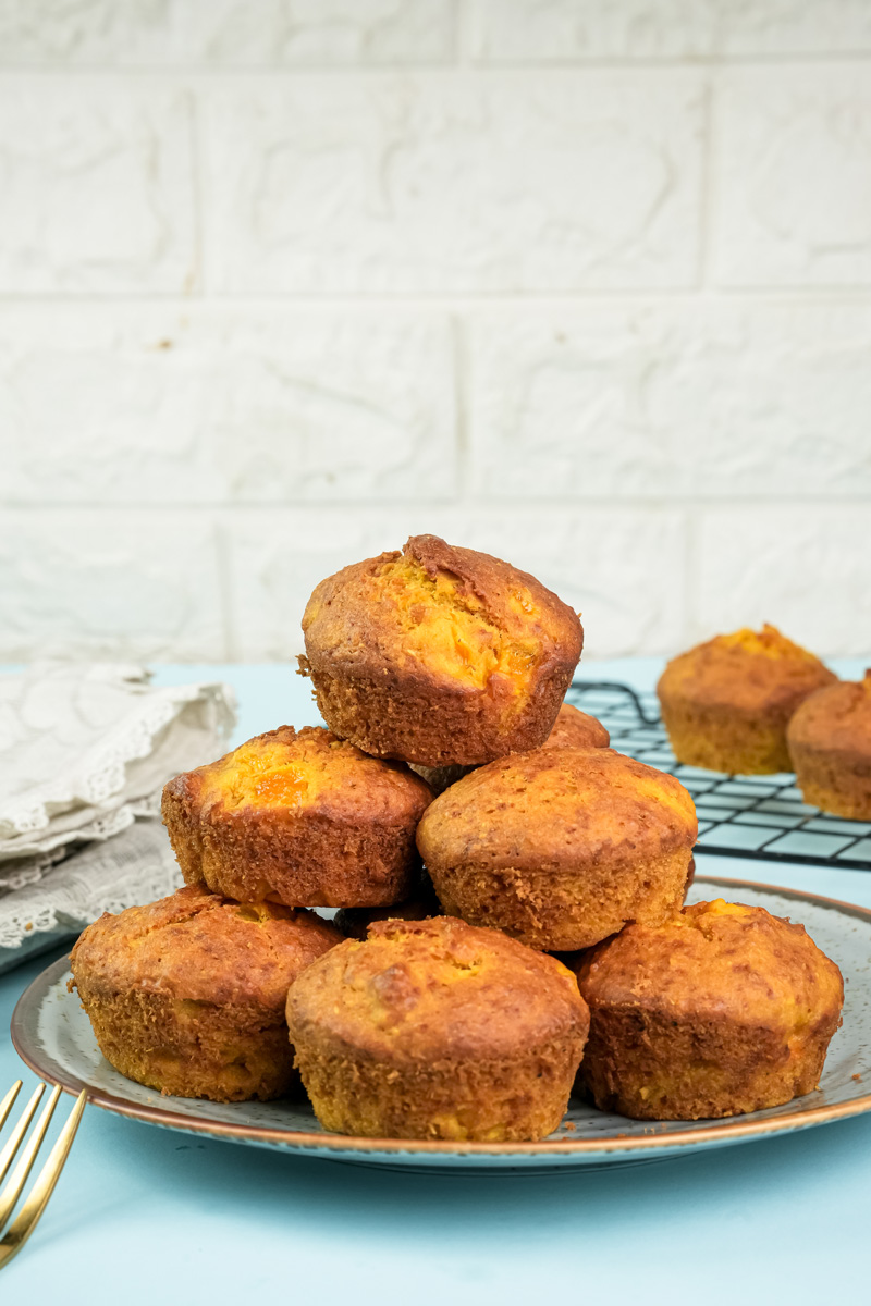 Fresh mango muffins with one cut in half showing texture