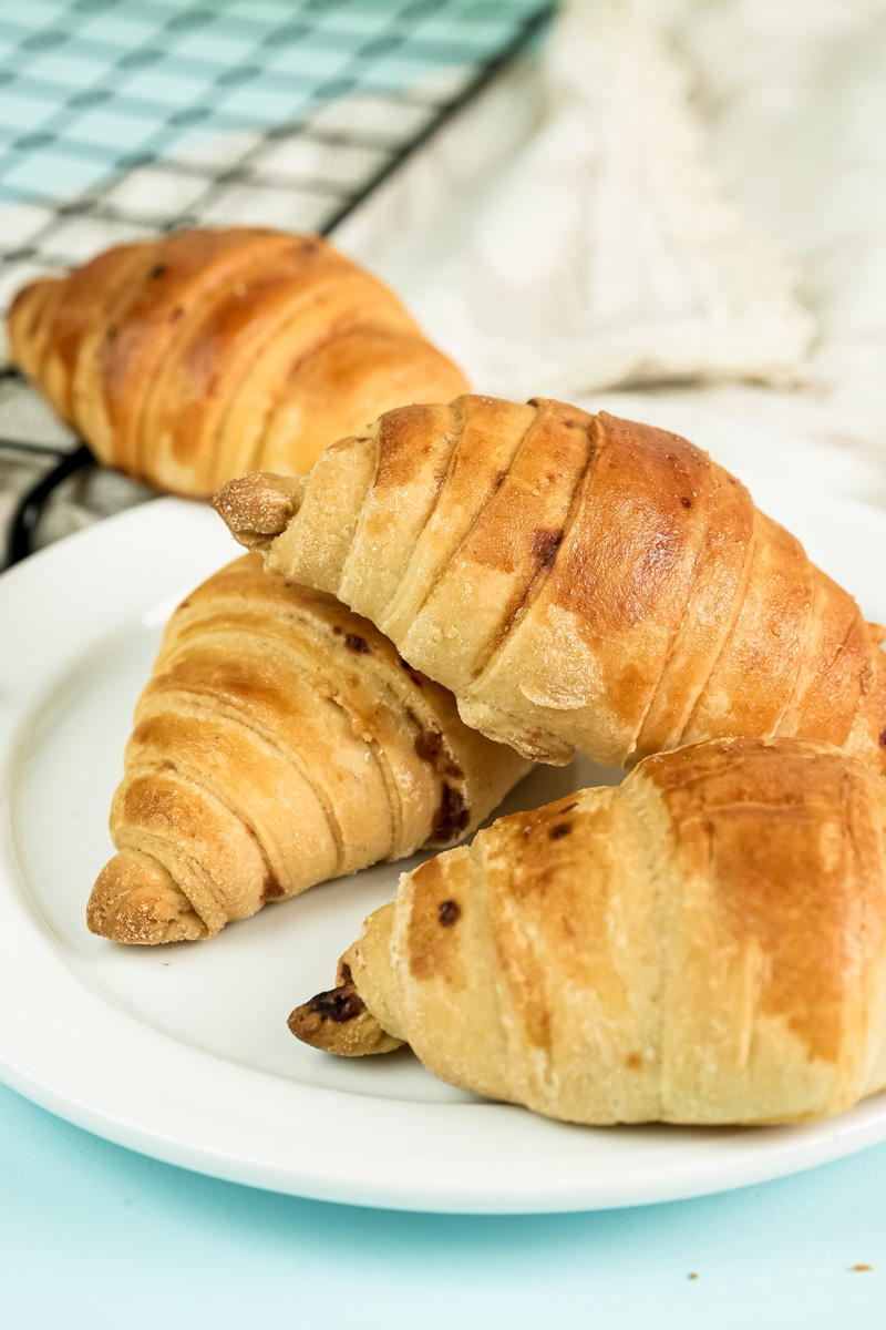 Freshly baked croissant bread with raisins on serving plate