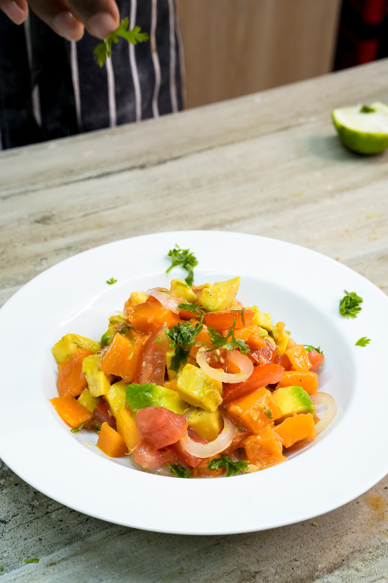 Garnishing mango avocado salad with fresh cilantro