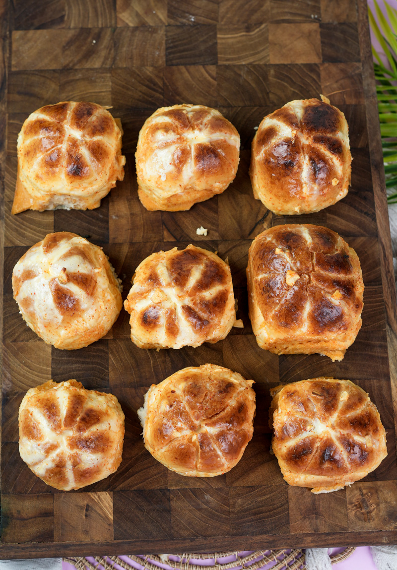 Golden Korean buns with cross-hatch tops on wooden board