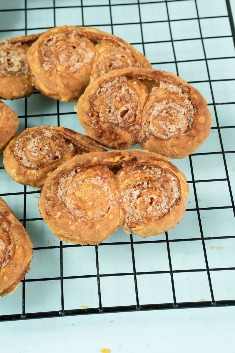 Golden baked palmiers cooling on wire rack