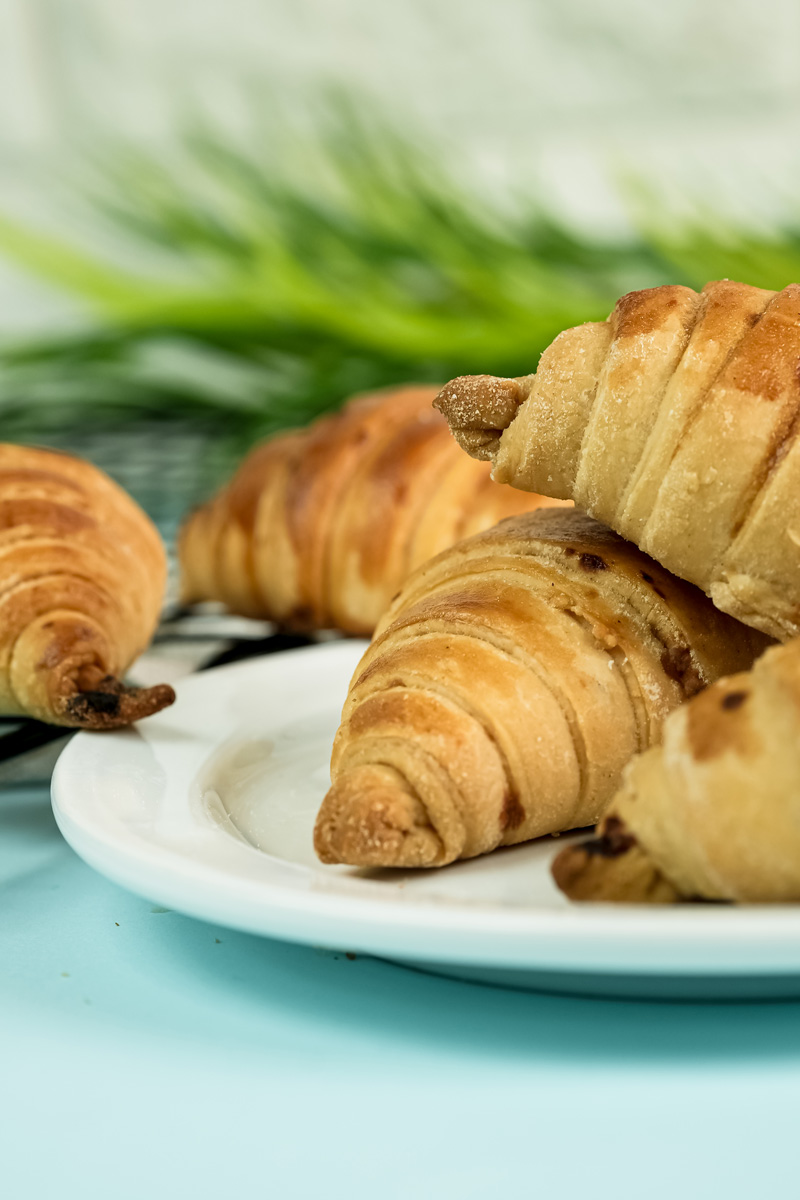 Golden brown raisin croissants served on white plate