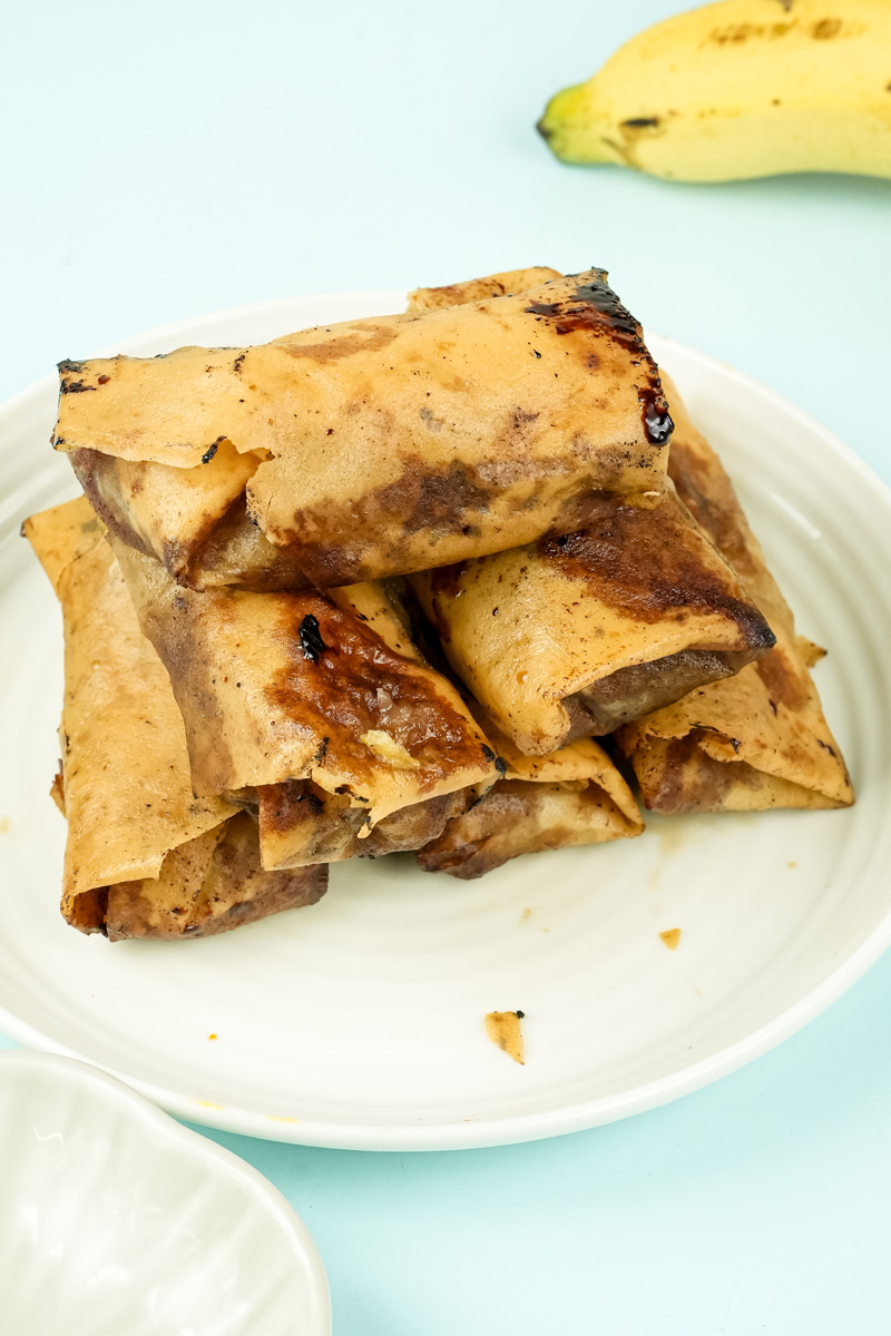 Golden fried banana lumpia on white plate