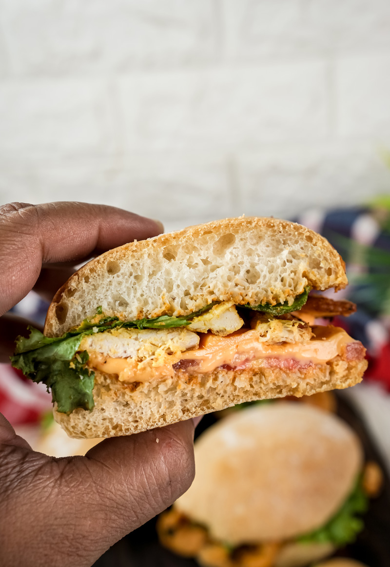 Hand holding ciabatta sandwich cross-section with visible layers
