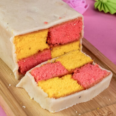 Homemade Battenberg cake sliced to show pink and yellow pattern