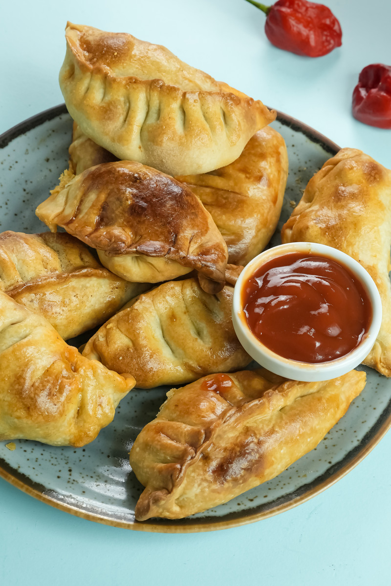 Homemade chicken empanadas with chili peppers and sauce