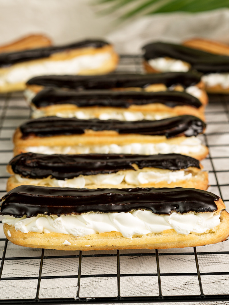 Homemade eclairs with dark chocolate topping cooling after baking