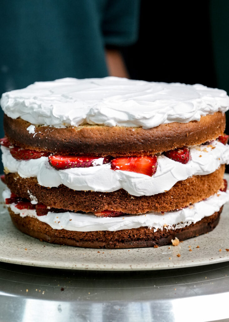 Homemade layered strawberry shortcake with whipped cream and fresh strawberries