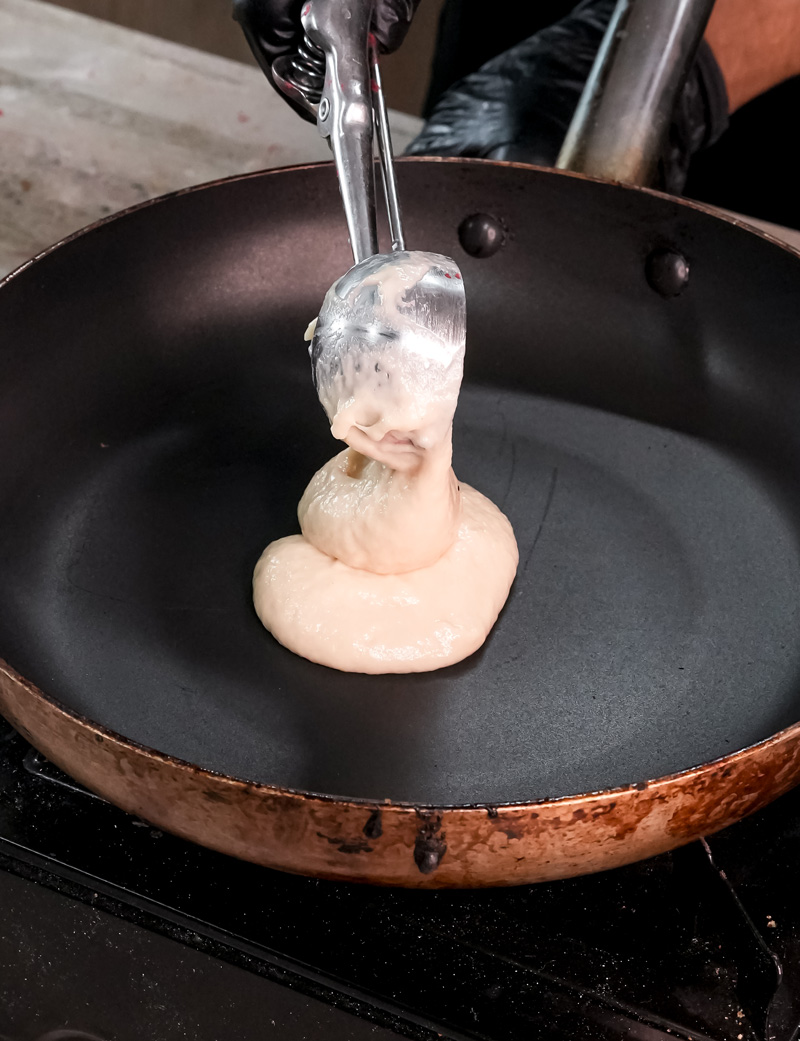 Gluten free pancake cooking in non-stick pan until golden