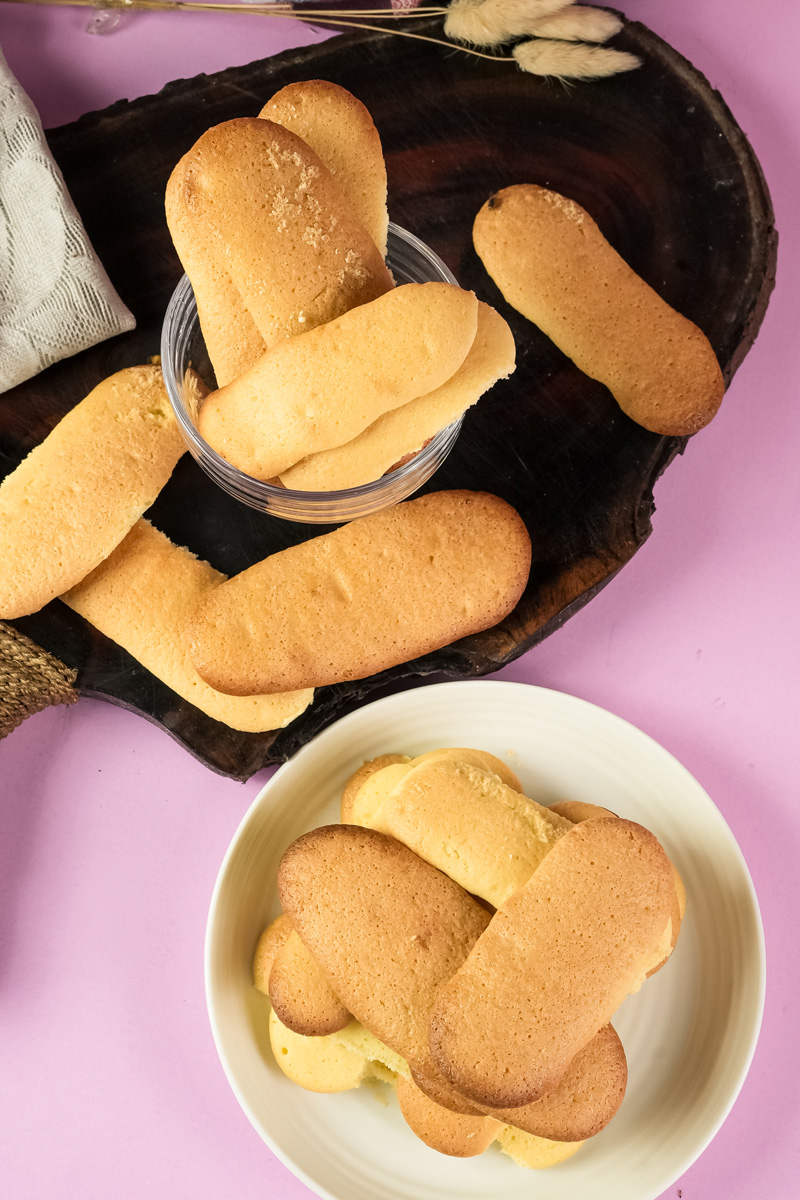 Ladyfinger cookies on wooden board and in serving bowl