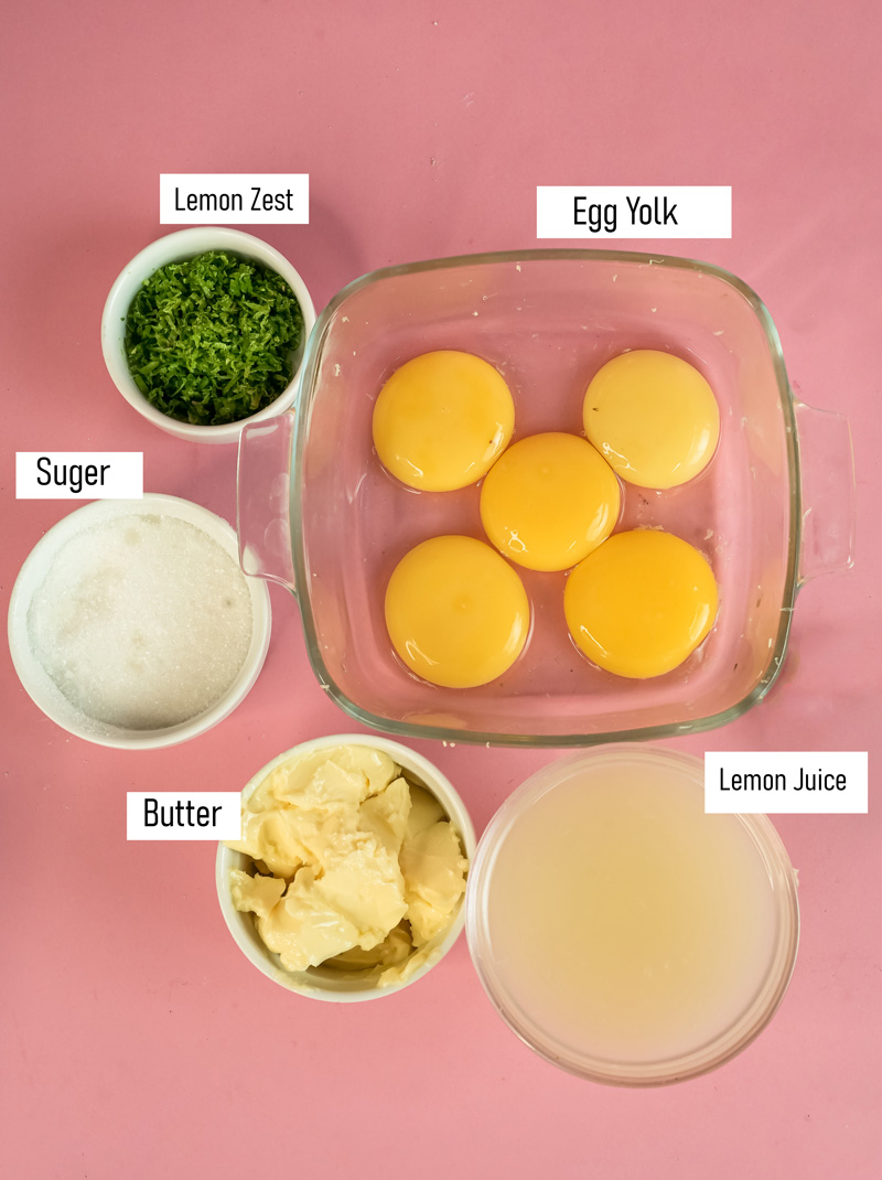 Lemon curd ingredients laid out - egg yolks, sugar, butter, lemon juice and lemon zest