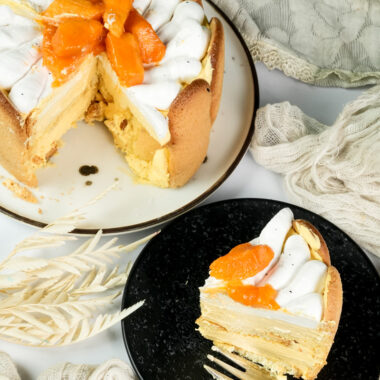 Mango charlotte cake with slice showing interior layers and mango topping