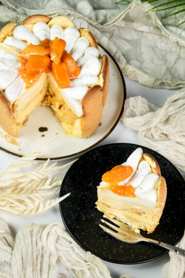 Mango charlotte cake with slice showing interior layers and mango topping