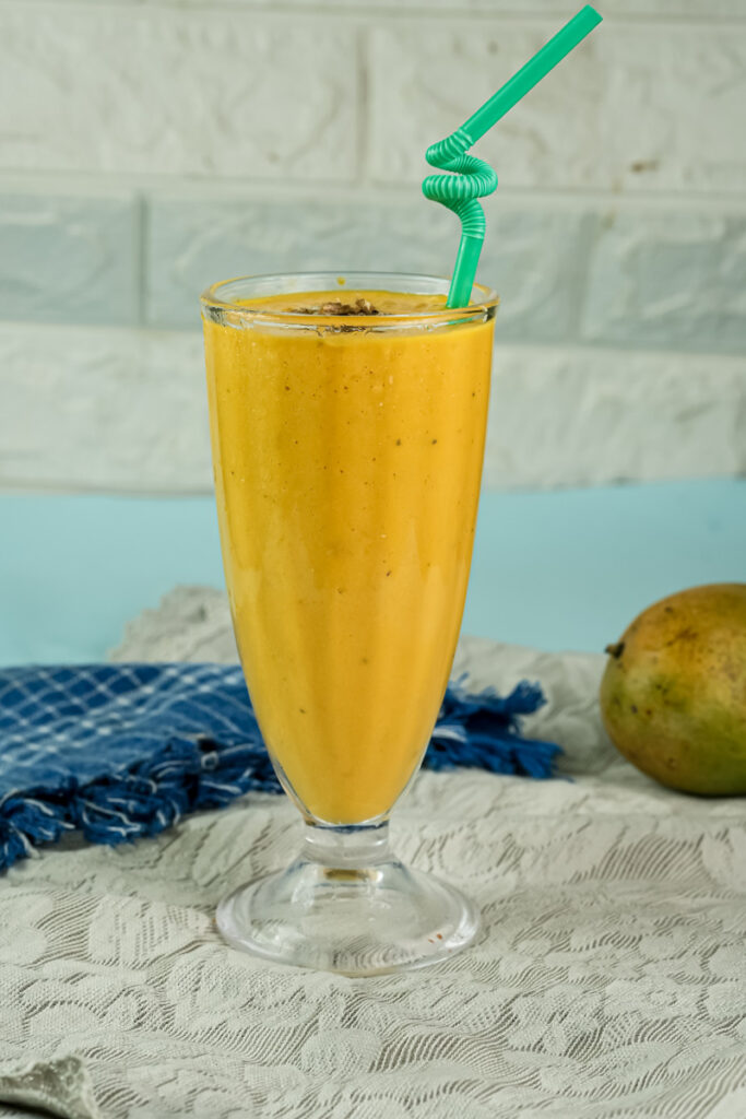 Mango lassi drink with decorative green straw