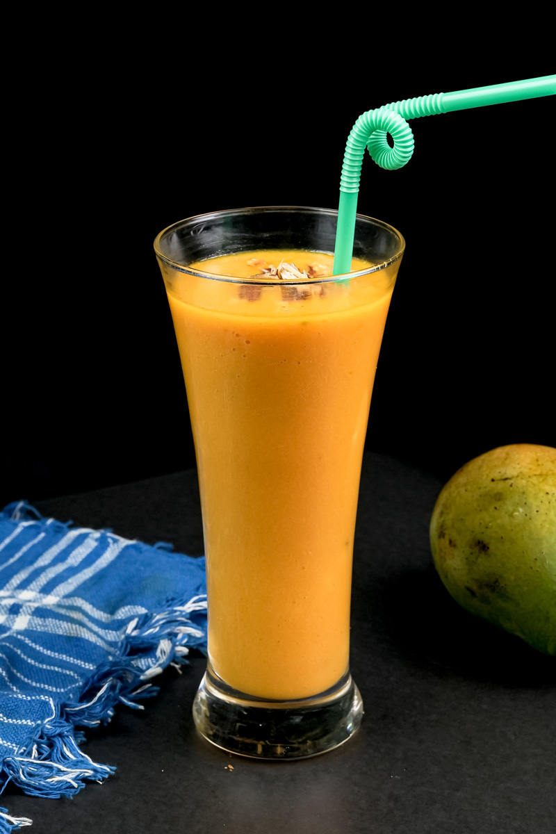 Mango milkshake with decorative green curly straw