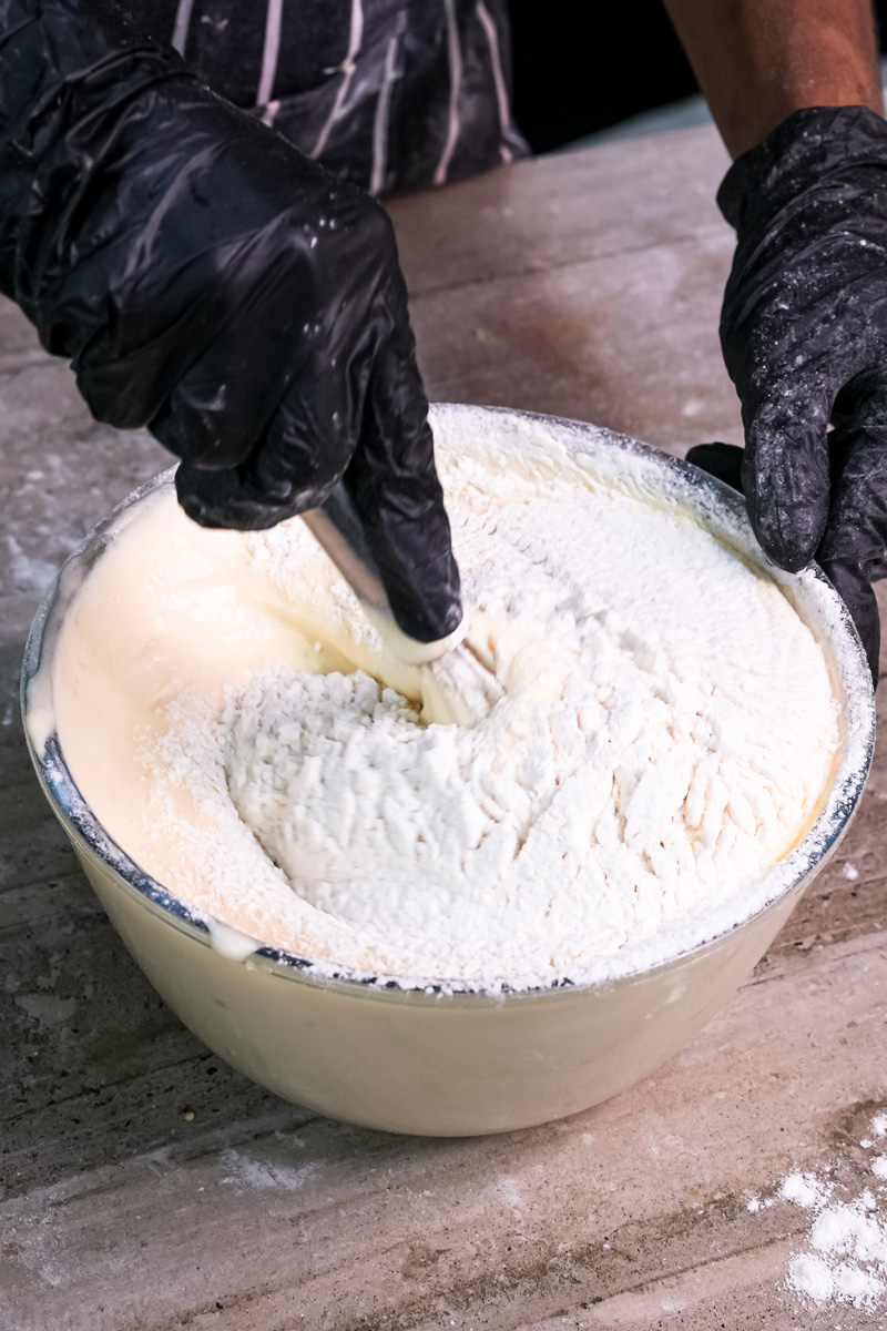 Mixing flour into ladyfinger cookie batter by hand