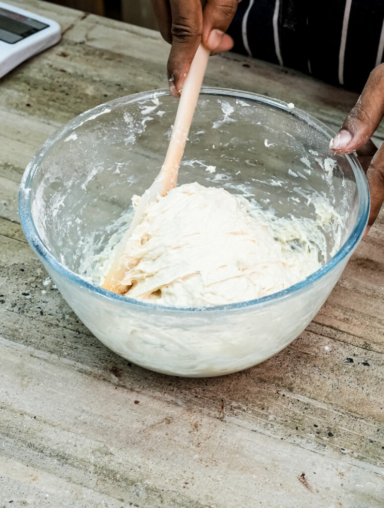 Mixing focaccia bread dough with wooden spoon