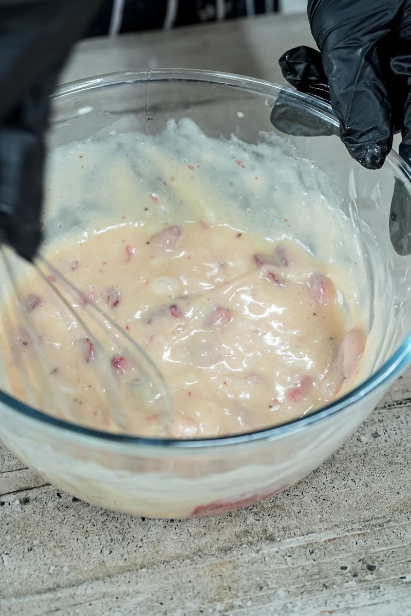 Mixing strawberry earthquake cake batter with fresh strawberry pieces