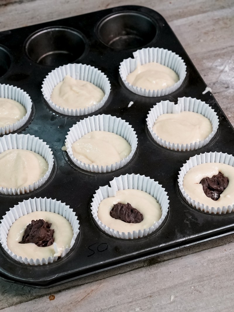 Muffin batter in liners with Nutella dollops