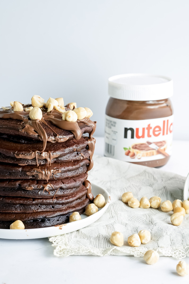Side view of Nutella pancake stack with chocolate drizzle