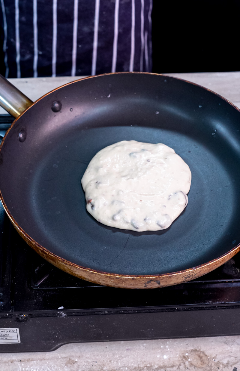 Oreo pancake batter cooking in non-stick pan
