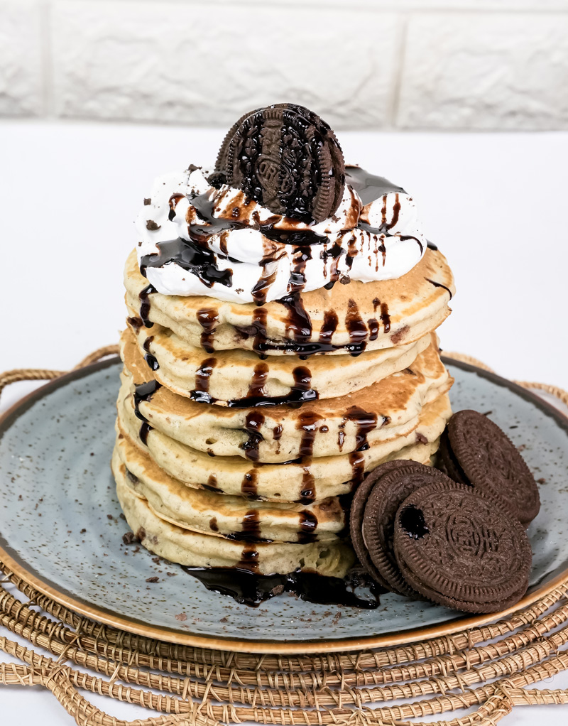 Oreo pancakes tower with chocolate sauce drizzle and cookie garnish