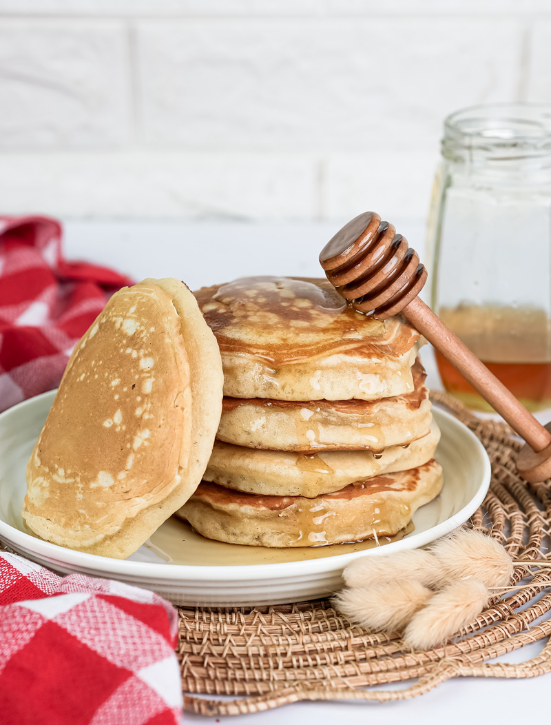 Perfect stack of gluten free pancakes with honey drizzle and mason jar