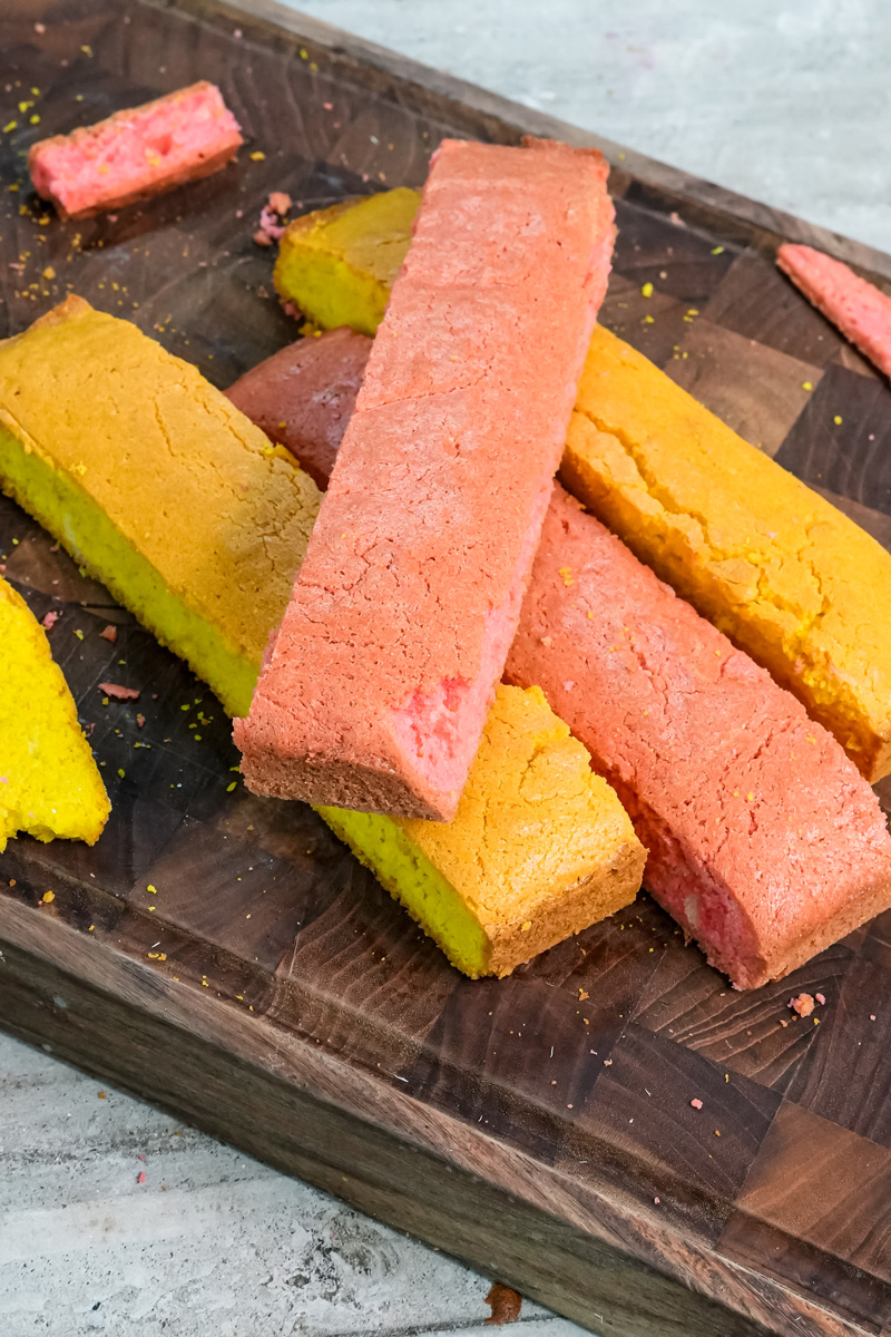 Pink and yellow cake strips arranged for Battenberg assembly