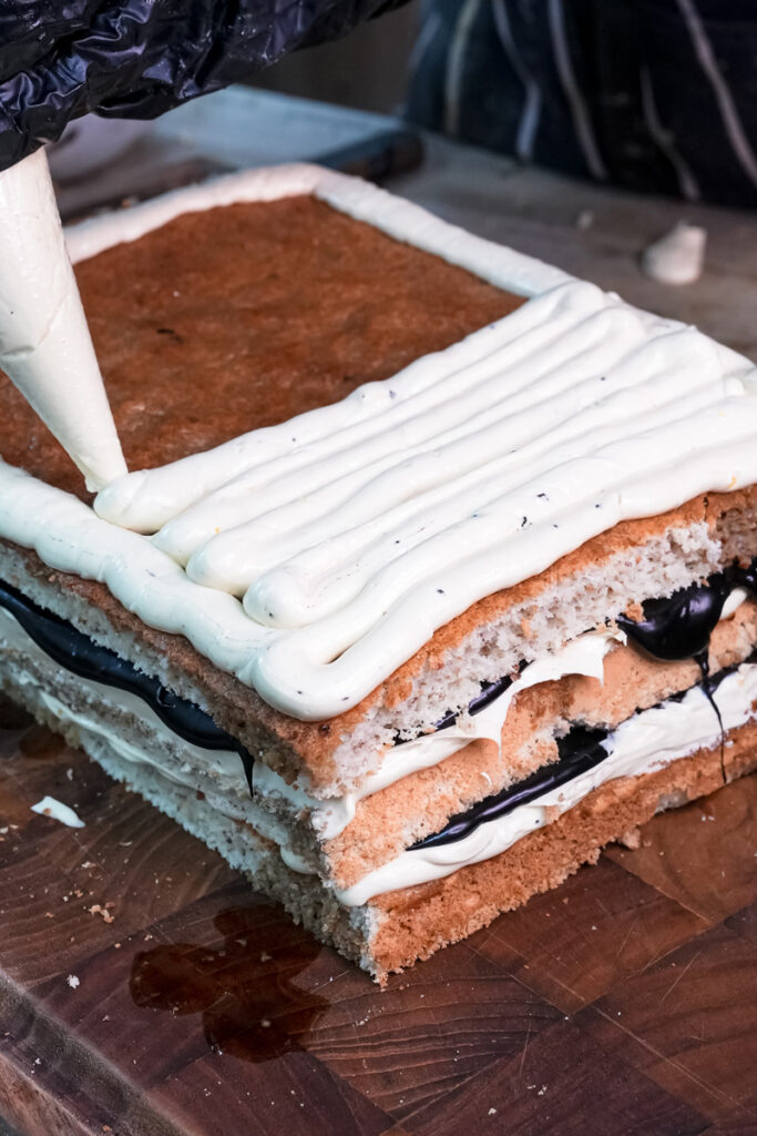 Spreading dark chocolate glaze on opera cake final layer