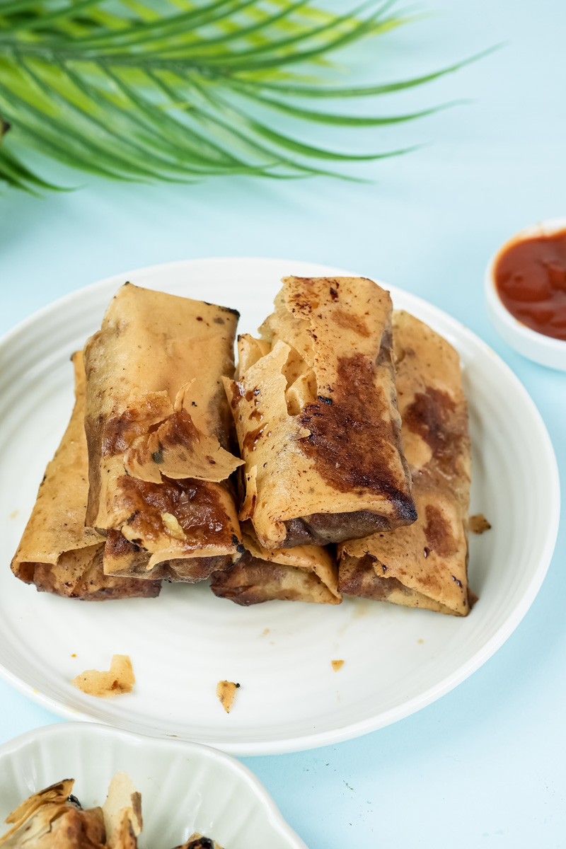 Plated banana lumpia with sauce and garnish