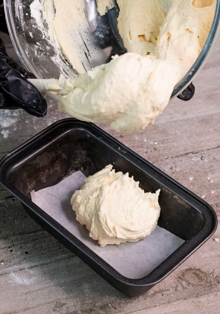 Pouring Madeira cake batter into greased loaf pan