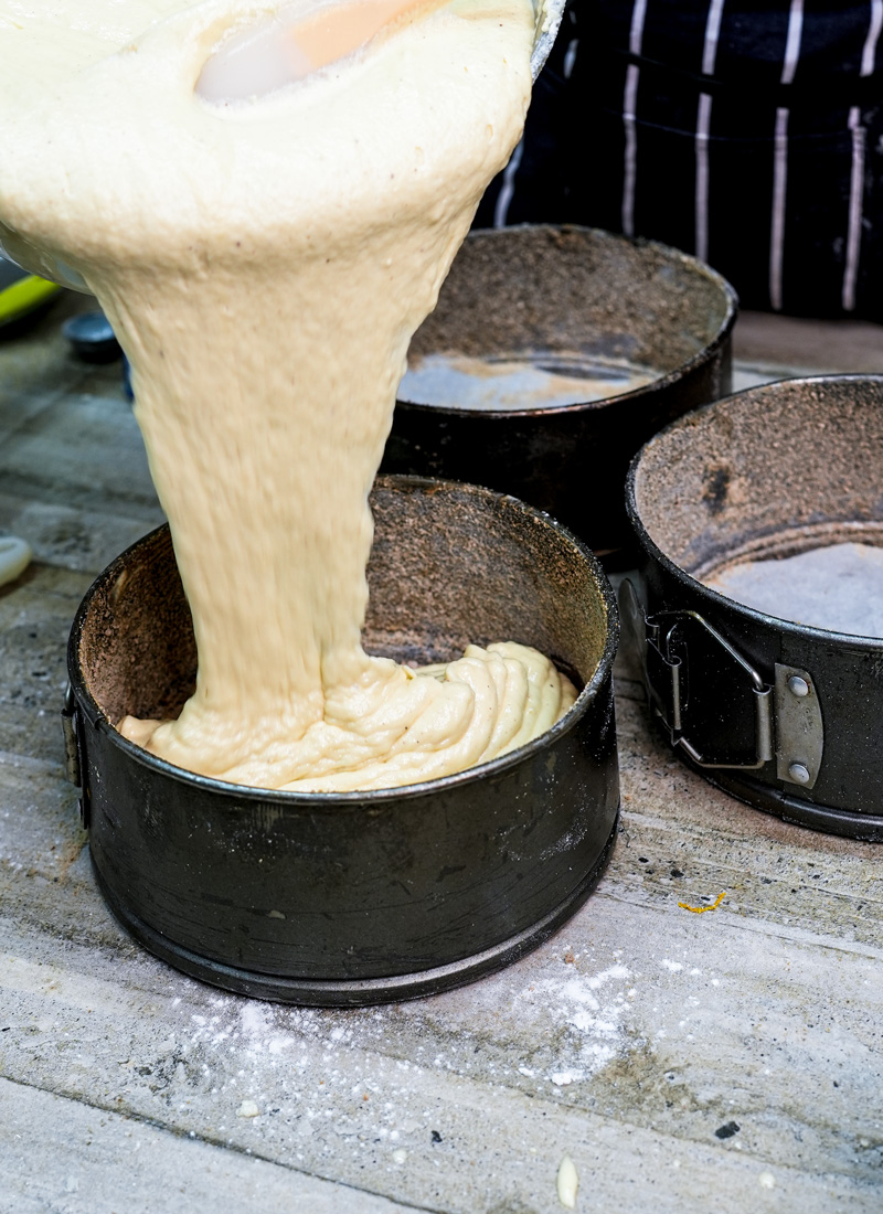 Pouring churro cake batter into springform baking pans