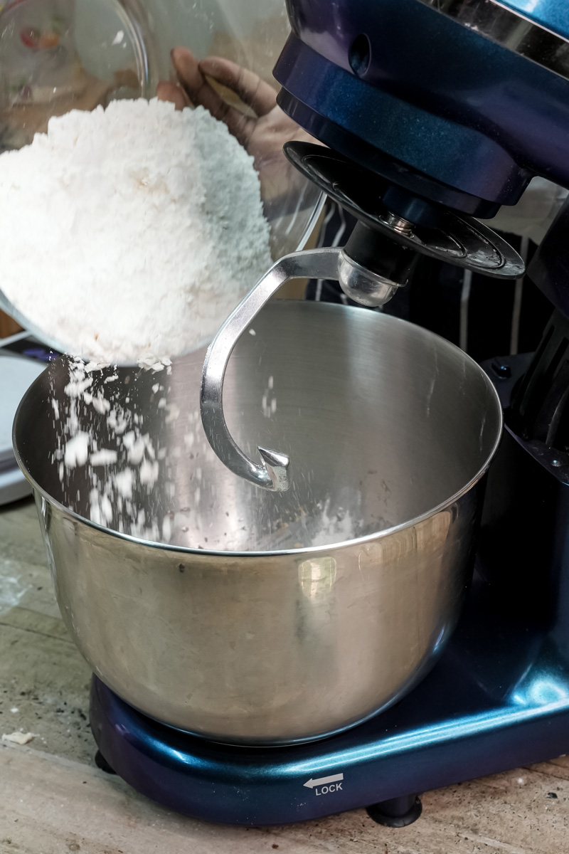 Pouring flour into stand mixer for bun dough