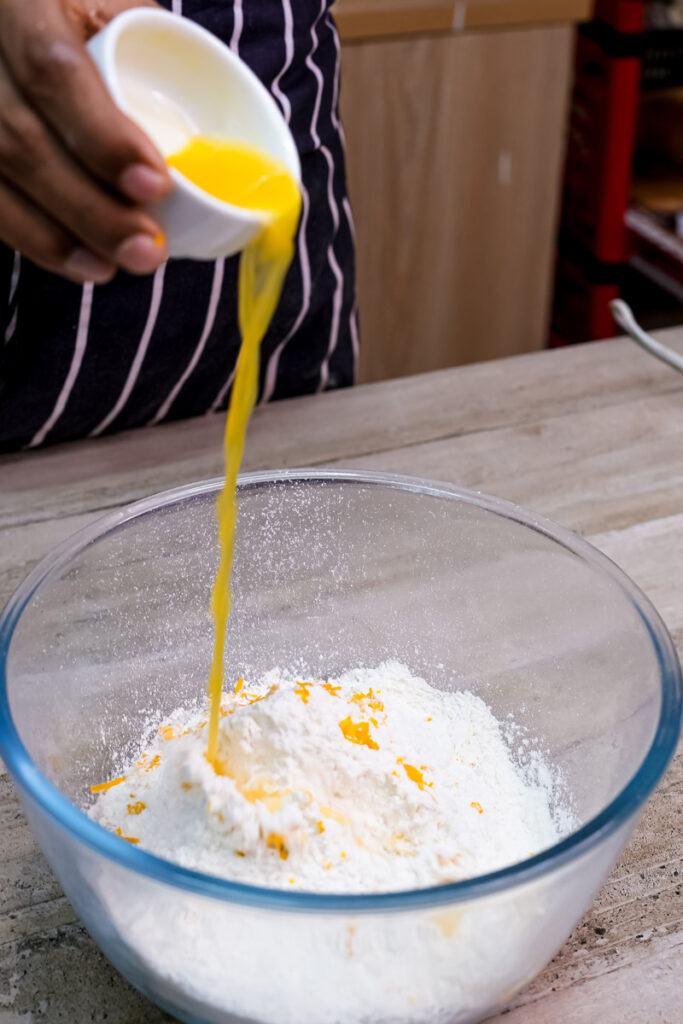 Pouring fresh orange juice into citrus cake batter