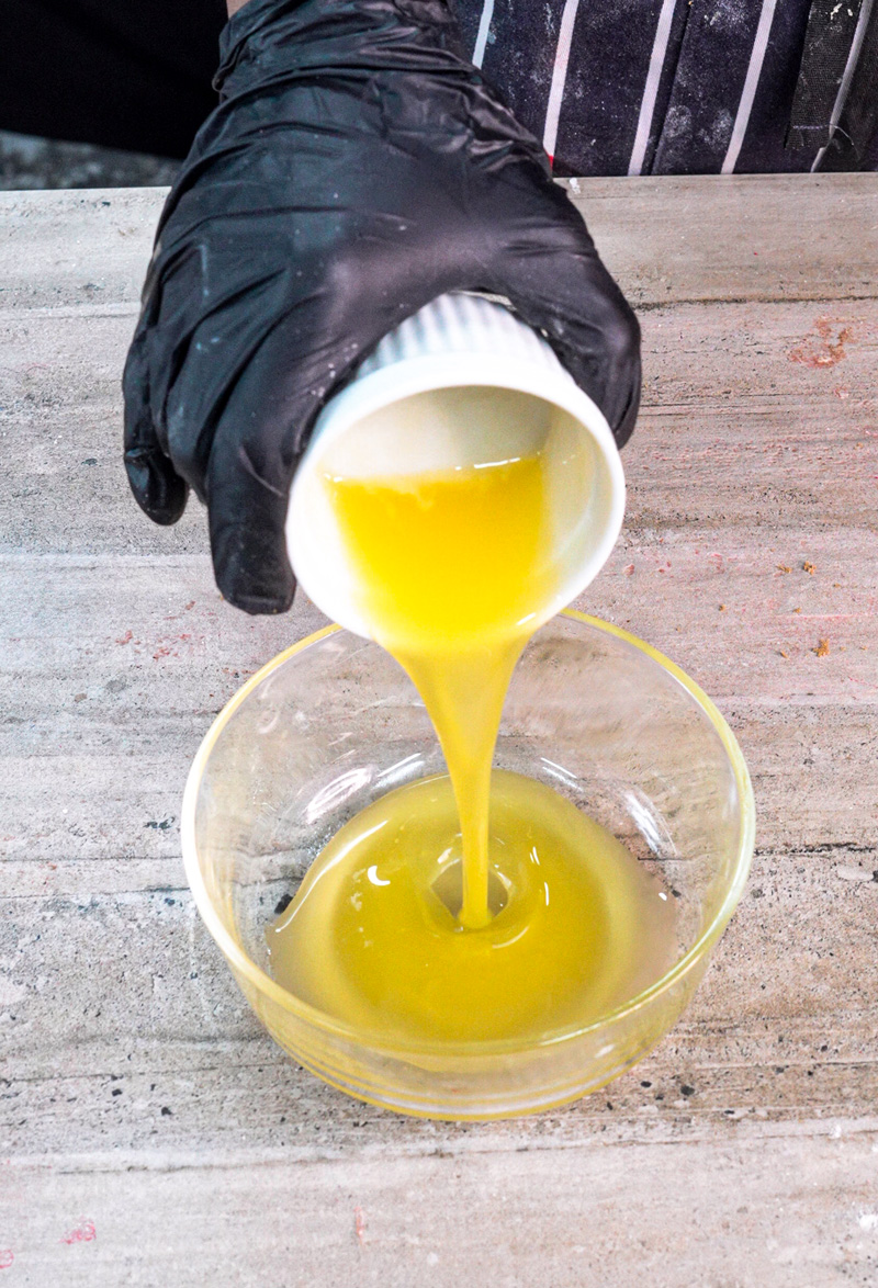 Pouring melted butter into glass bowl for cinnamon roll pancake batter