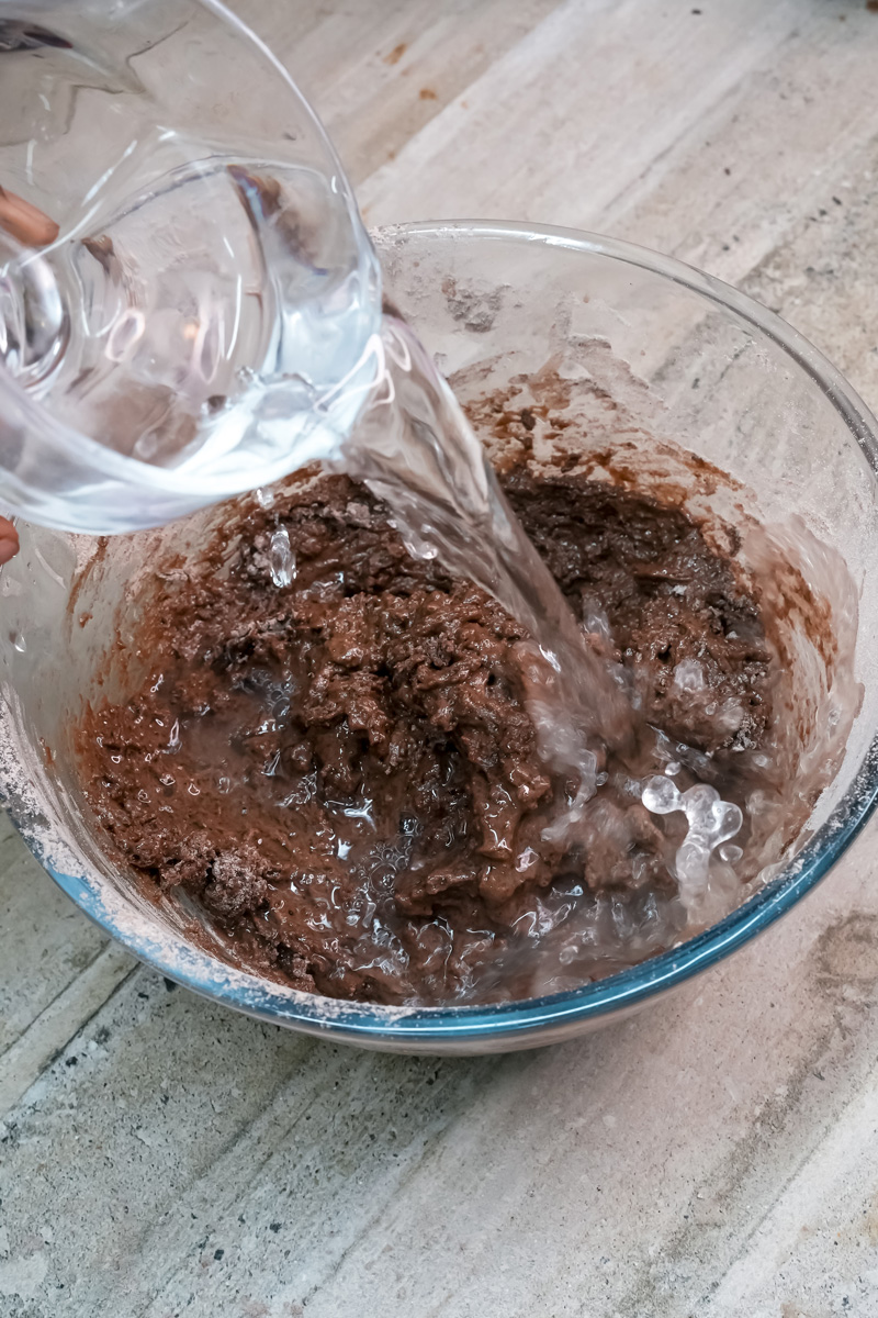 Pouring milk into chocolate cake batter