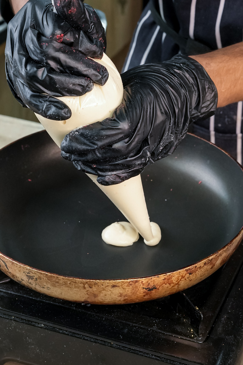 Pouring pancake batter from squeeze bottle onto non-stick pan